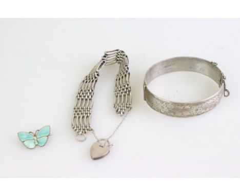 Silver gate link bracelet with padlock clasp; silver hinged bangle, the upper half with bright cut floral and foliate decorat