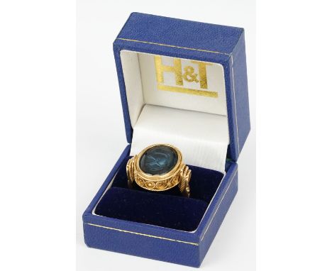 Intaglio 18ct yellow gold ring, the oval blue glass panel with Roman centurion's head intaglio, rubover set, rope twist surro
