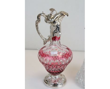 Cranberry glass silver plated mounted claret jug, grape and vine decoration to the foot, collar and handle, the finial modell