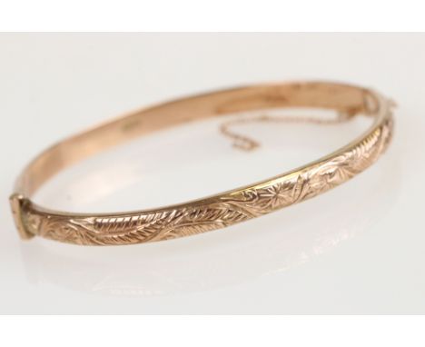 9ct rose gold hinged bangle, the upper half with bright cut foliate decoration, tongue and box clasp, width approx 5mm 