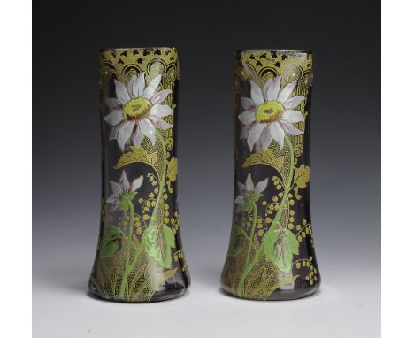 A pair of matching, amethyst glass vases decorated with painted enamel flowers and art deco designs. Signed on the side of on