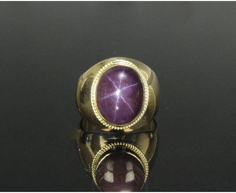 Natural untreated cabochon star ruby set in a marked and tested 18K gold ring. Oval ruby of approximately 12-13 carats. Total