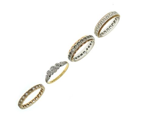 Three stone diamond ring, the shank stamped 18ct and Plat, together with three eternity rings set white stones, various sizes