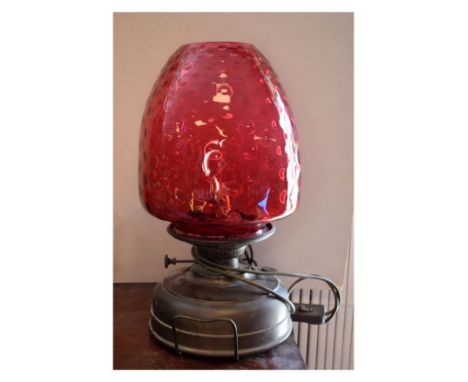 Early 20th Century oil/paraffin lamp with dimpled cranberry glass shade on brass reservoir, later converted to table lamp, 44