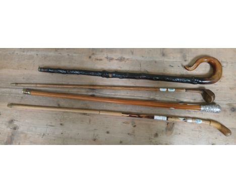 A group of four antique/vintage walking sticks comprising a cane with white metal buckle collar, a malacca stick with white m