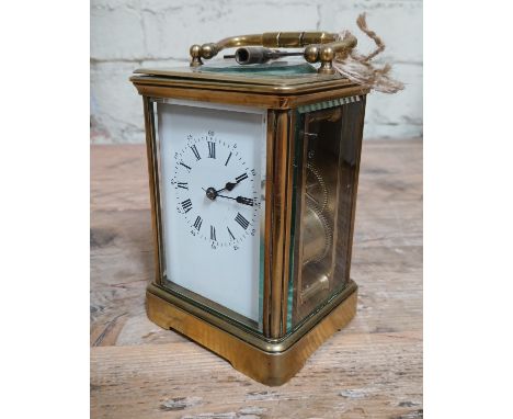A brass striking carriage clock with key.Condition:- General wear through age and use, small crack to top right of back panel
