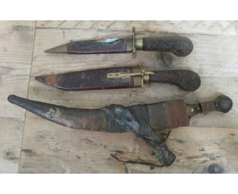 A North African dagger and sheath and two Eastern carved wood and steel bladed knives, all AF  