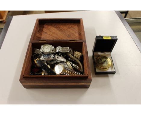 An inlaid trinket box containing a compass and various wrist watches 