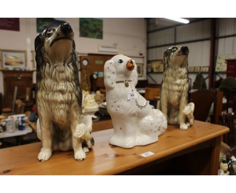 A Staffordshire style spaniel; and pair of pottery model dogs 
