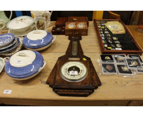 An oak cased barometer with presentation plaque; and four wooden trinket boxes 