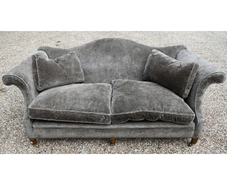 An early 20th century Howard &amp; Sons two seat hump back sofa in serge dralon upholstery, with scroll arms, raised on six s