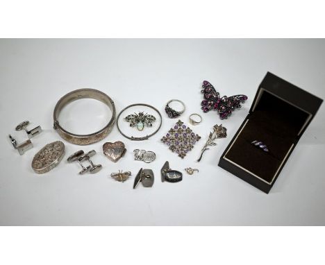 A collection of silver and white metal jewellery including oval half hinged bangle, an amethyst and diamond twist design ring