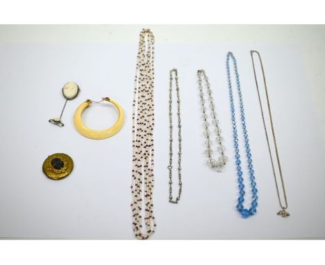 A small collection of costume jewellery including facetted glass bead necklaces, boar tusk in the form of a bangle, oval came