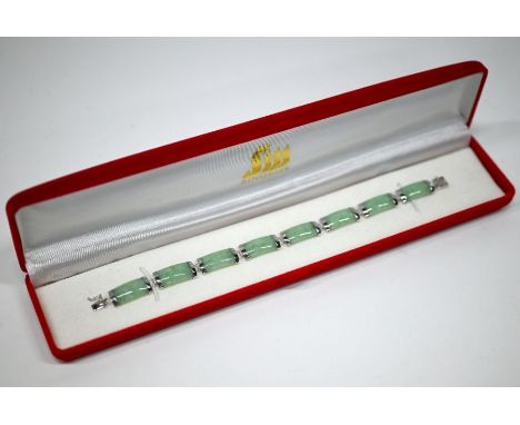 A pale green jade bracelet formed of rectangular links with white metal settings, stamped 14k 535