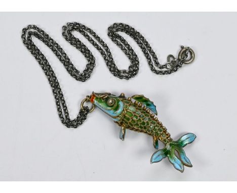 A mid 20th century enamel pendant in the form of an articulated fish, on white metal chain, 5 cm long