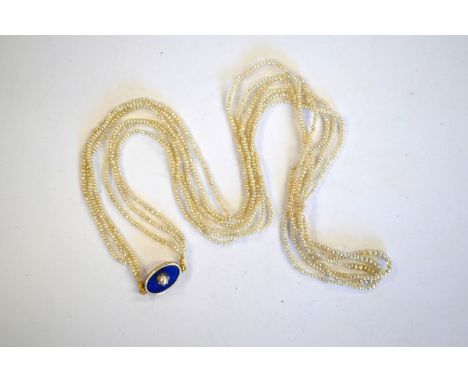 An antique seed pearl necklace formed of three fine strands of pearls threaded onto oval blue and white enamel clasp with cen