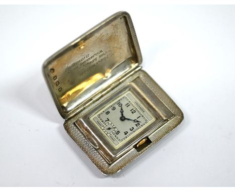 A 1930s silver Crusader travel watch with 15-ruby Swiss movement and rectangular silvered dial, in engine-turned purse-case w