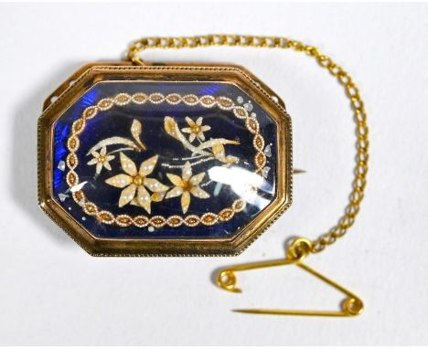 A Victorian rectangular mourning brooch featuring a bouquet of seed pearl flowers on blue enamel base set beneath glass, 3 x 