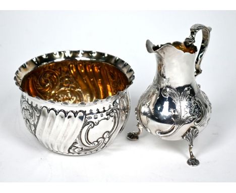 A Victorian silver Rococo Revival pear-shaped cream jug with floral and scroll embossed and chased decoration, scroll handle 