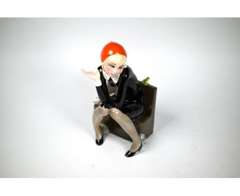 An Art Deco Lenci (Turin) pottery figure of a seated girl, 'Nella' by Helen König Scavini, a book and a frog on her bench, da