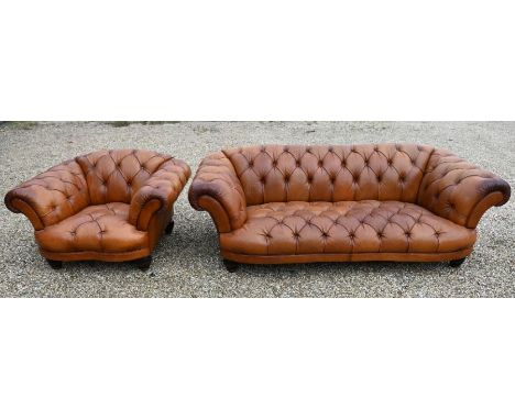 A large contemporary antiqued buttoned brown leather Chesterfield style sofa and matching armchair, raised on bulbous moulded