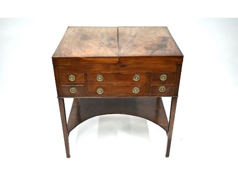 A George III gentlemans mahogany dressing stand or washstand, the twin hinge-over tope enclosing&nbsp; a fitted interior cent