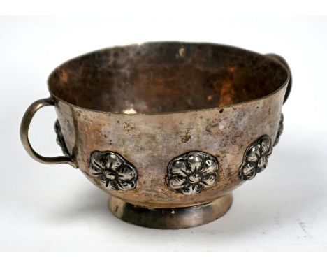 A Continental (probably Indian) low-grade white metal two-handled basin on raised foot-rim, applied with floral bosses, 8oz (