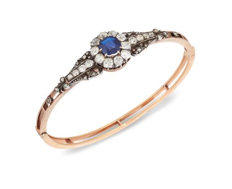 A Victorian gold, sapphire and diamond bangle, the hinged half-hoop of openwork design, the central mixed cushion-cut sapphir