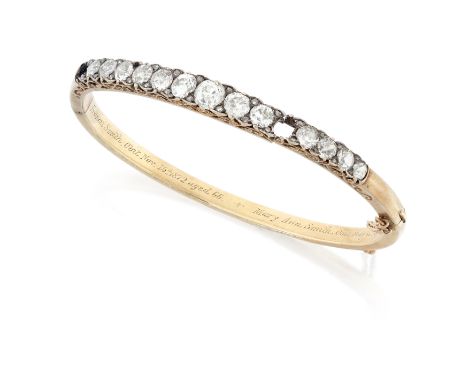 A late 19th century diamond set hinged bangle, the upper half with a row of graduated old cut diamonds, the centre diamond wi