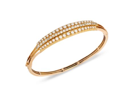 A 15ct gold diamond and half pearl bangle, the central row of old cut diamonds bordered by rows of graduated half pearls, to 