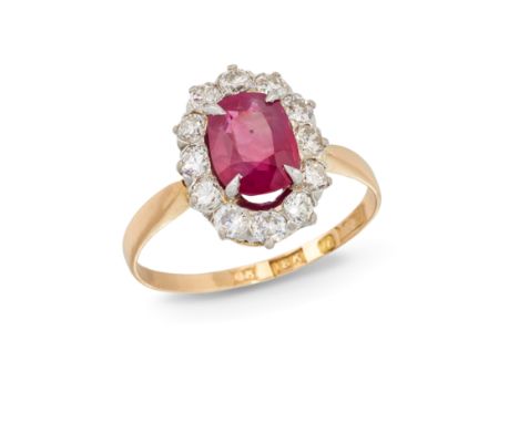 A ruby and diamond cluster ring, the oval cushion cut four claw-set ruby weighing 1.37 carats, within brilliant-cut diamond s