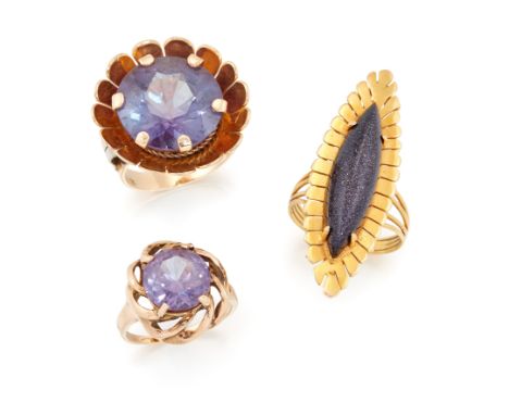 Three dress rings, comprising: two synthetic corundum single stone rings each with decorative border; and a navette-shaped av