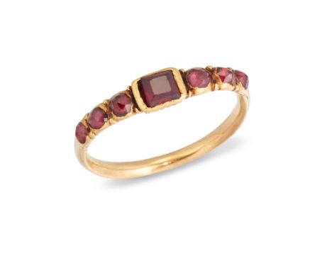 An 18th century gold garnet ring, set with a central facetted garnet (probable replacement) to domed faceted garnet three sto