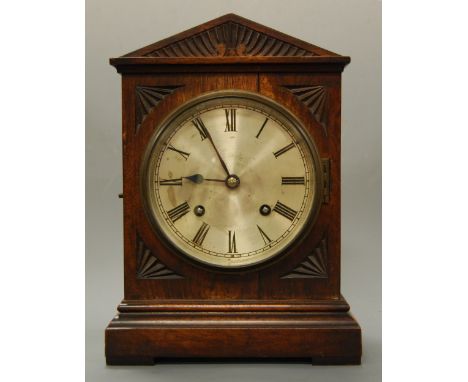 A Victorian mahogany cased mantel clock, having a silvered dial with Roman numerals and eight day movement striking on a gong