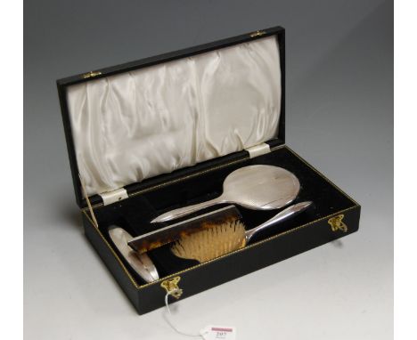 An Art Deco style silver mounted four piece dressing table set to include hand mirror, hair brush, clothes brush and comb in 