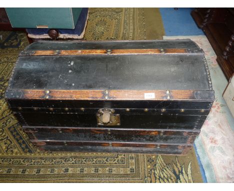 A black domed travel Trunk with brass studs, 32'' long x 19'' x 21''.