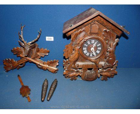 A Cuckoo clock with crossed rifles and stags head finial