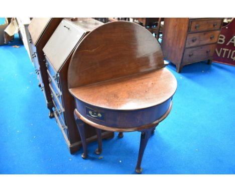 A George II mahogany demi lune fold over tea table having two narrow wing drawers , with cabriole gate leg