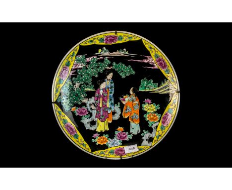 Japanese Meiji Period Famille Noir Decorated Charger, depicting figures offering a bowl of peaches in landscape, with a shape