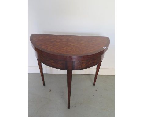 An Edwardian parquetry fold over demi-lune card table on square tapering legs, 75cm tall x 80cm, generally good condition som