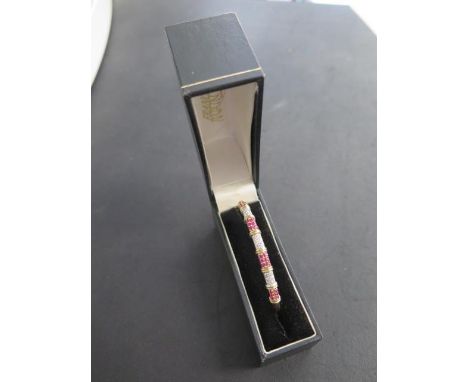 A hallmarked 9ct yellow gold diamond and ruby hinged bangle, 6.5cm x 5.5cm external, approx 10.4 grams in good condition