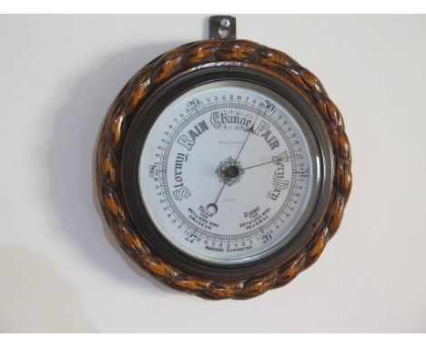 An oak aneroid barometer Riddels Limited Belfast, 23cm diameter, generally good condition 