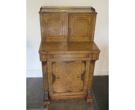 A good Victorian walnut writing desk with a two door brass galleried top with fitted interior above a frieze drawer with writ