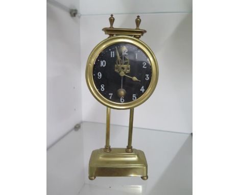 A brass twin pillar drum gravity clock, 26cm tall, ticks but stops 