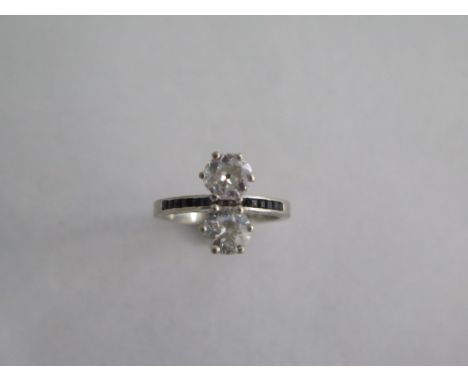 A hallmarked 18ct white gold two stone diamond ring set with small sapphires at each side ,diamonds approx 0.75ct, ring size 