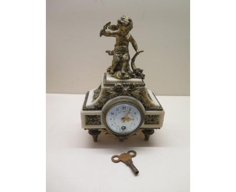 A 19th century French 8 day clock, white marble with brass decorations on four brass tapering feet, a cherub to the top, the 
