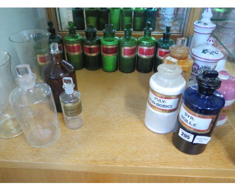 A coloured group of 14 chemist bottles, 3 glass measures and 3 ceramic jars, all but one of the green bottles have stuck stop