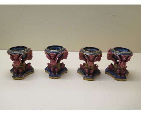 Four 19th century Worcester salts, each with a three dragon support decorated in rose red, the bowls lapis blue with gilded s