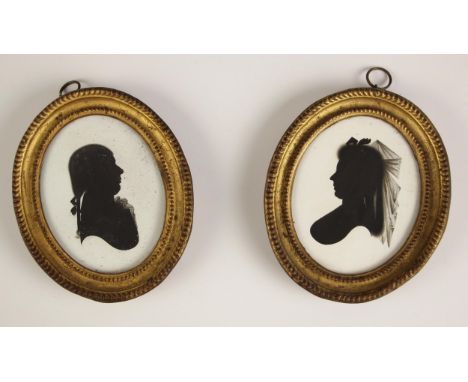 Manner of John Miers (British, 1758-1821),A pair of oval bust length portrait silhouettes on plaster, one depicting a lady fa