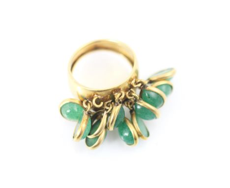 A yellow metal and green stone dress ring, the wide tapered band suspending ten tear drop shaped cabochon stones within yello